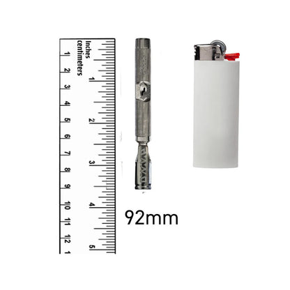 Das Produkt The M7 Vaporizer von DynaVap ist aus Titan und in der Farbe silber-grau. Es steht zwischen einem weißen Feuerzeug und einem durchsichtigen Lineal, um die Größe zu veranschaulichen. Das Produkt befindet sich auf einem weißen Hintergrund.