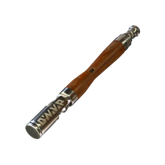 The WoodWynd Vaporizer von DynaVap. Der Verdampfer aus Titan in Holzoptik liegt quer auf einem weißen Hintergrund.