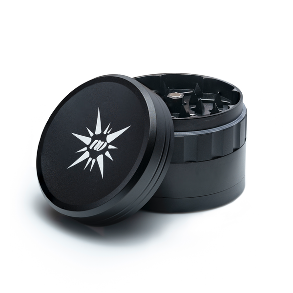 Vierteiliger Grinder aus Aluminium von der Marke NV in der Farbe schwarz und mit einem Durchmesser von fünfzig Millimeter auf einem weißen Hintergrund.