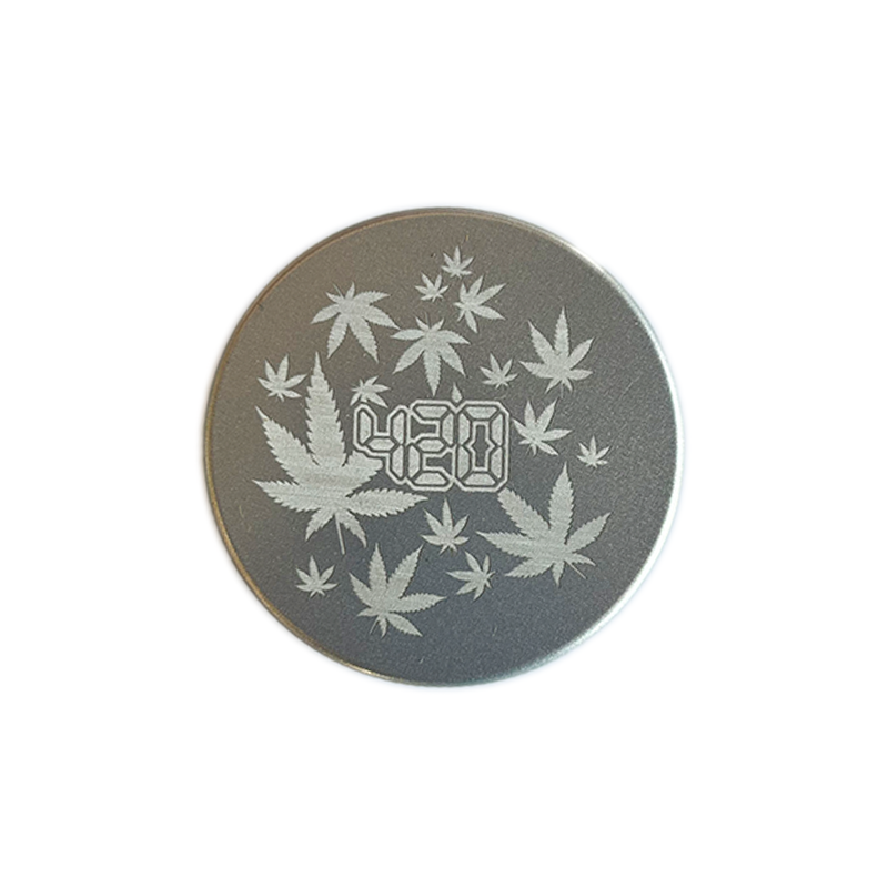 Keramik Grinder mit einem 63 Millimeter Durchmesser von der Marke NV. Die Farbe ist grau, mit einem silbernen Aufschrift und Hanfblättern.